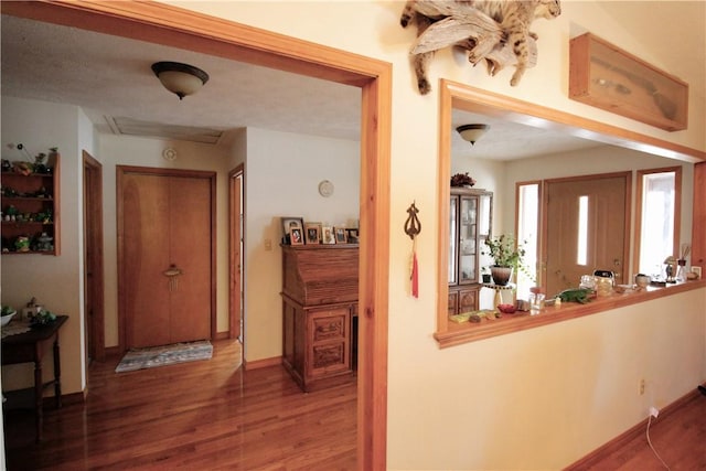 hallway featuring baseboards and wood finished floors