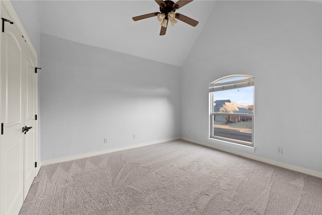 carpeted empty room featuring baseboards, high vaulted ceiling, and a ceiling fan