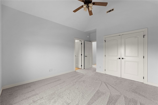 unfurnished bedroom with baseboards, visible vents, carpet floors, high vaulted ceiling, and a closet