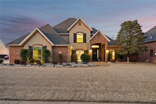 view of front facade featuring brick siding and a shingled roof