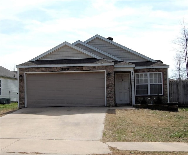 view of front of house with driveway, central AC unit, an attached garage, and fence