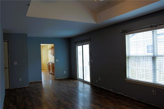 unfurnished room with dark wood-style floors and lofted ceiling