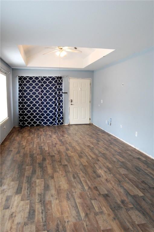 unfurnished room with a ceiling fan, a raised ceiling, and wood finished floors