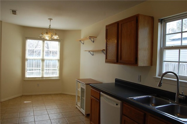 kitchen featuring dark countertops, visible vents, brown cabinetry, white dishwasher, and a sink