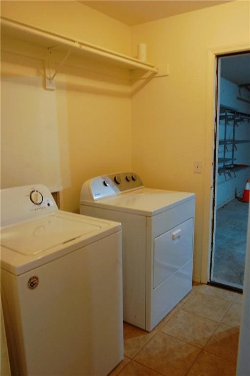 clothes washing area with light tile patterned floors, laundry area, and washing machine and dryer