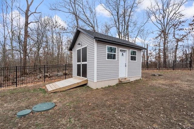 view of outbuilding with entry steps, a fenced backyard, and an outbuilding