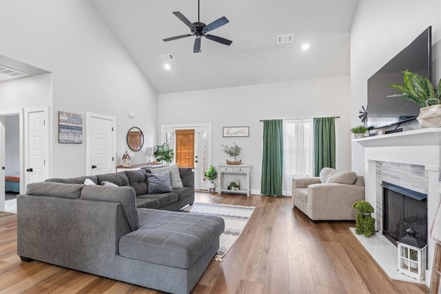 57 Cromarty Dr, Bella Vista, AR 72715 - living area with high vaulted ceiling, a ceiling fan, a tile fireplace, and wood finished floors