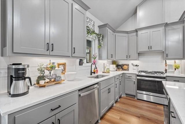 57 Cromarty Dr, Bella Vista, AR 72715 - kitchen featuring stainless steel appliances, gray cabinetry, lofted ceiling, a sink, and backsplash