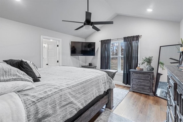 bedroom with ceiling fan, vaulted ceiling, and wood finished floors