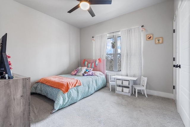 carpeted bedroom with ceiling fan and baseboards