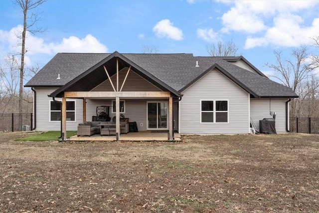 back of house featuring roof with shingles, fence, an outdoor living space, and a patio