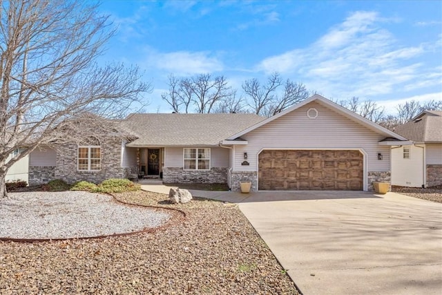 ranch-style house featuring a garage, concrete driveway, and stone siding