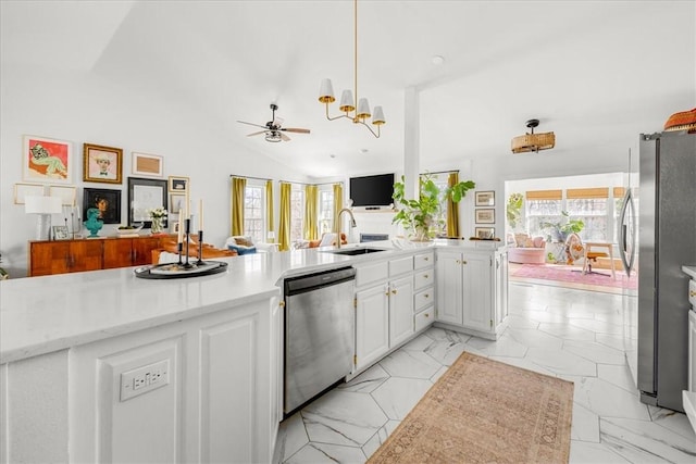 kitchen with lofted ceiling, marble finish floor, appliances with stainless steel finishes, and a sink