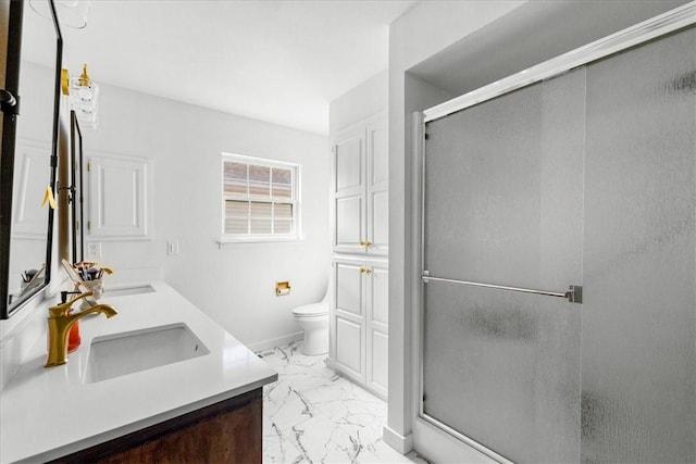 bathroom with marble finish floor, a stall shower, a sink, and toilet