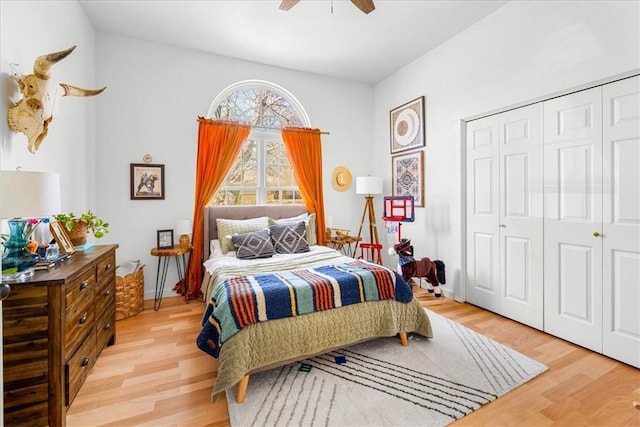 bedroom featuring ceiling fan, light wood finished floors, and a closet