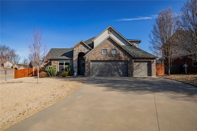 traditional-style home with concrete driveway, brick siding, and fence