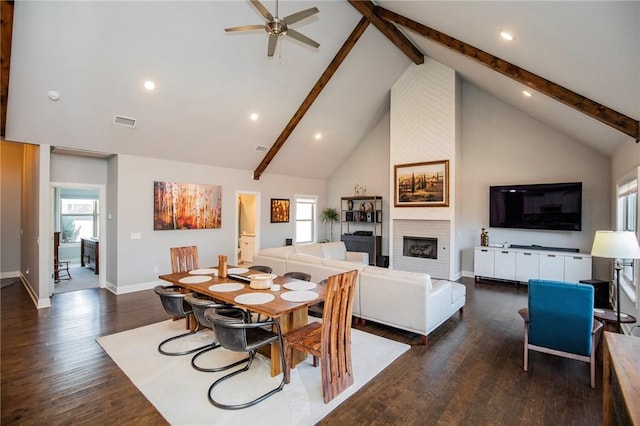 dining area with a fireplace, visible vents, dark wood-type flooring, and beamed ceiling