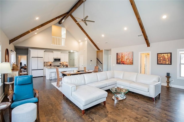 living area featuring dark wood-style flooring, a ceiling fan, high vaulted ceiling, beamed ceiling, and baseboards