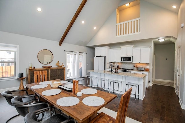 dining area featuring high vaulted ceiling, recessed lighting, dark wood finished floors, and baseboards