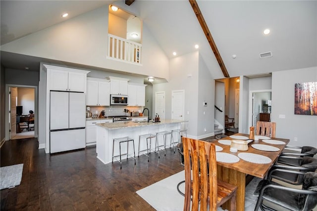 dining room featuring high vaulted ceiling, visible vents, baseboards, stairway, and dark wood-style floors