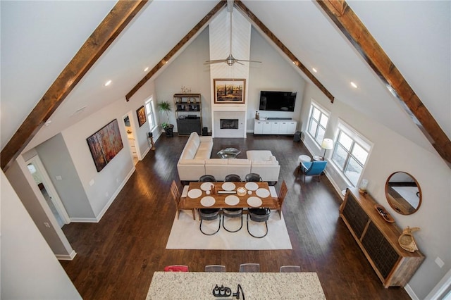 living room featuring a fireplace, high vaulted ceiling, beamed ceiling, and wood finished floors