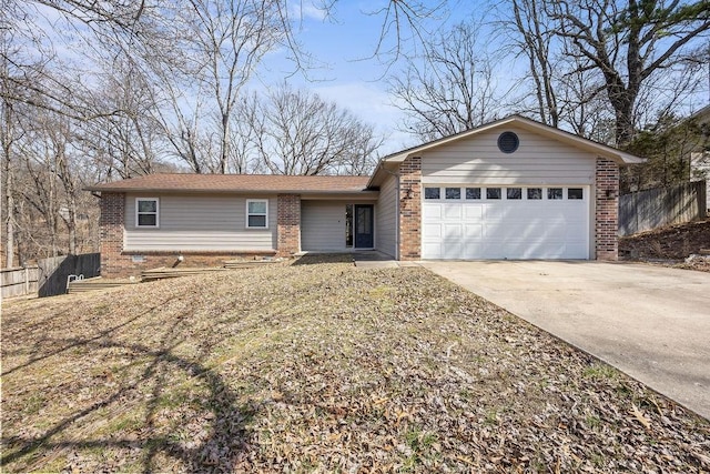 single story home with a garage, driveway, brick siding, and fence