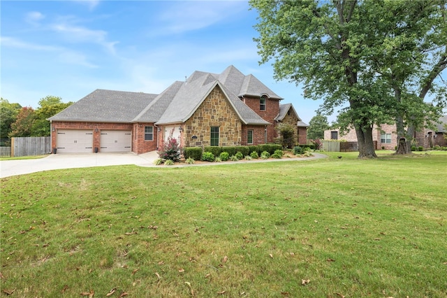 view of front of home featuring driveway, an attached garage, fence, and a front lawn