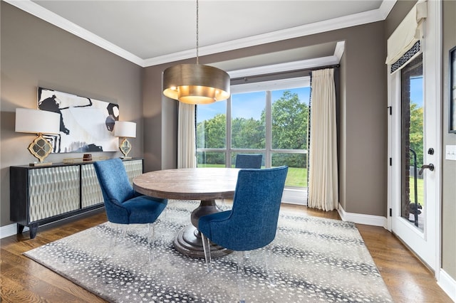 dining area with ornamental molding, wood finished floors, and baseboards