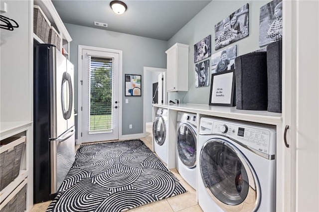 clothes washing area with cabinet space, visible vents, light tile patterned flooring, washer and dryer, and baseboards