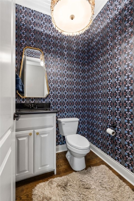 bathroom with toilet, baseboards, wood finished floors, and vanity