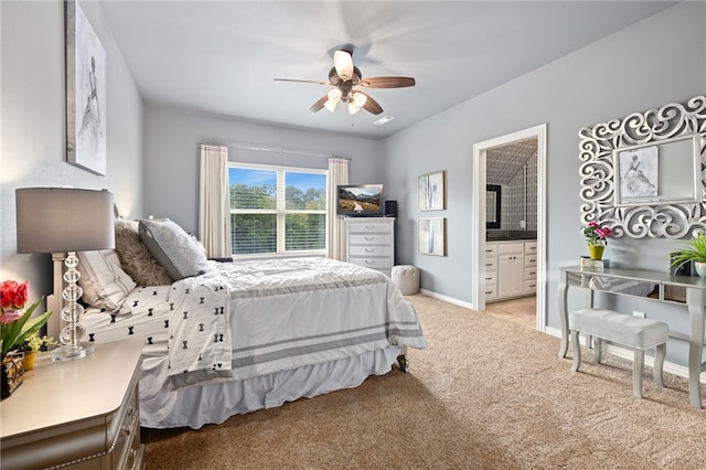 bedroom featuring light carpet, ceiling fan, ensuite bathroom, and baseboards