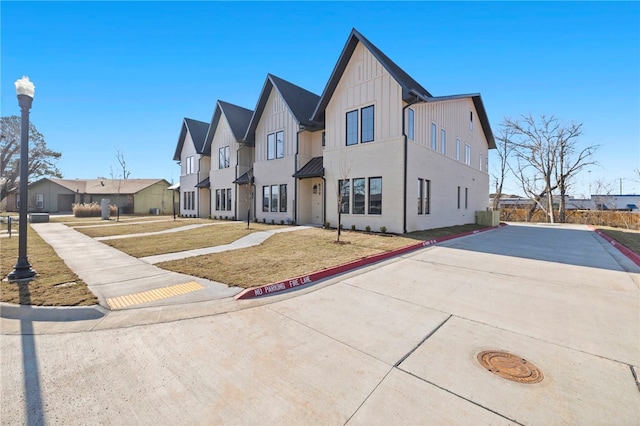 view of front of home featuring a residential view, a front lawn, and board and batten siding