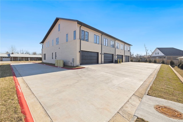 view of side of home with concrete driveway and an attached garage