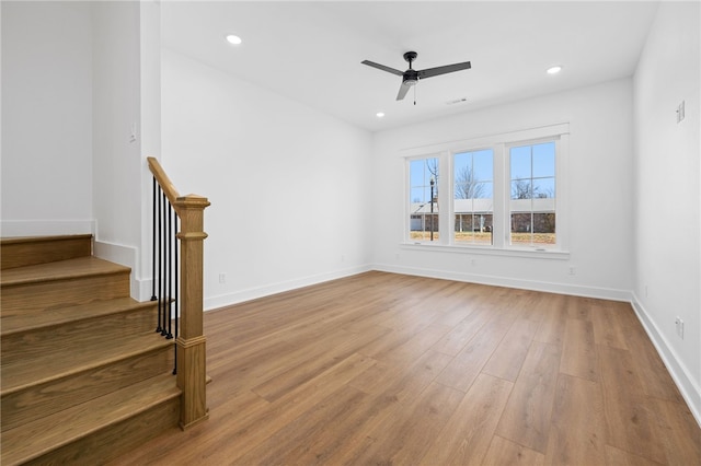 unfurnished room featuring baseboards, a ceiling fan, wood finished floors, stairs, and recessed lighting