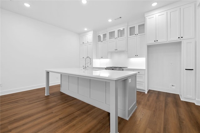 kitchen with dark wood-style floors, light countertops, white cabinets, and a sink