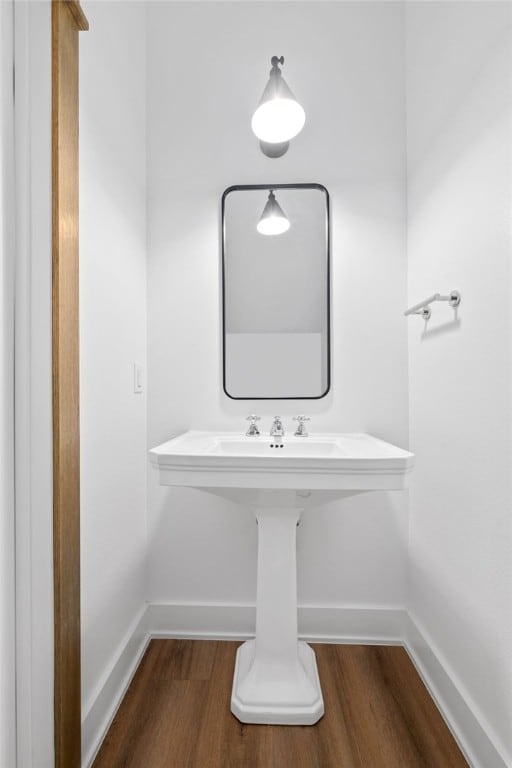 bathroom with baseboards and wood finished floors