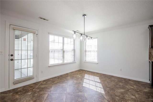 unfurnished dining area featuring visible vents, a textured ceiling, baseboards, and crown molding