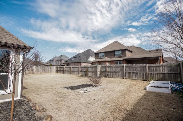 view of yard featuring a garden and a fenced backyard