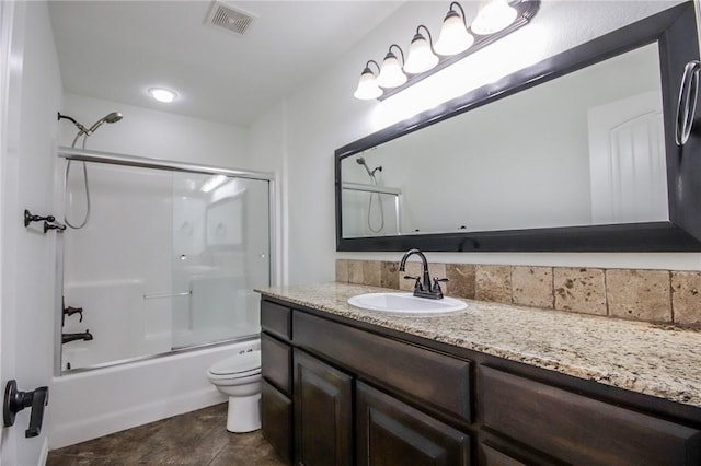 full bathroom featuring bath / shower combo with glass door, visible vents, toilet, vanity, and tile patterned flooring