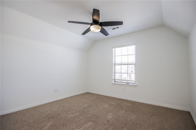 carpeted spare room featuring visible vents, vaulted ceiling, baseboards, and ceiling fan