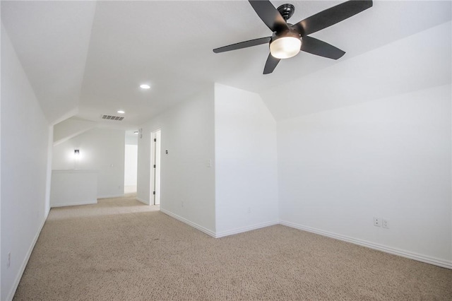 additional living space featuring visible vents, vaulted ceiling, and light carpet