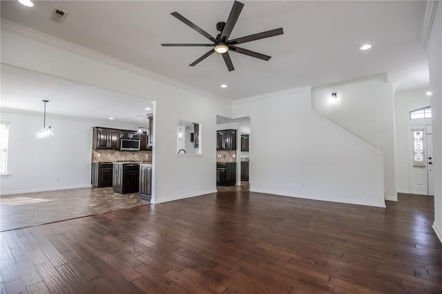 unfurnished living room with baseboards, dark wood-style flooring, ceiling fan with notable chandelier, crown molding, and recessed lighting