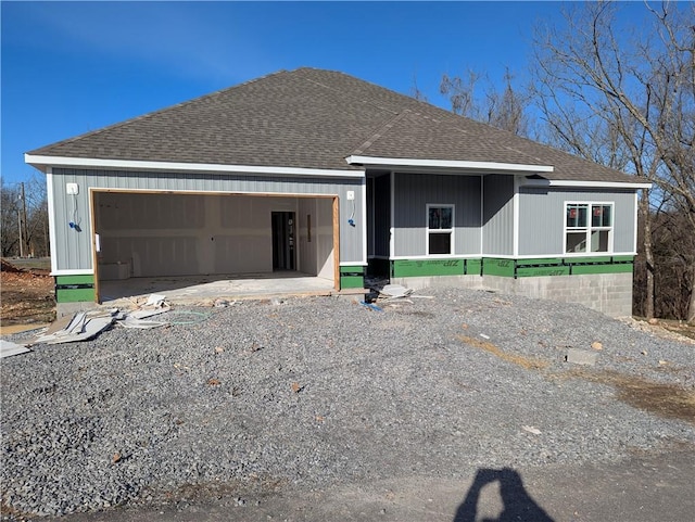 view of front of house with driveway, a garage, and roof with shingles