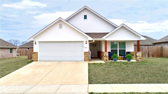 view of front of house with driveway, a front lawn, an attached garage, and fence