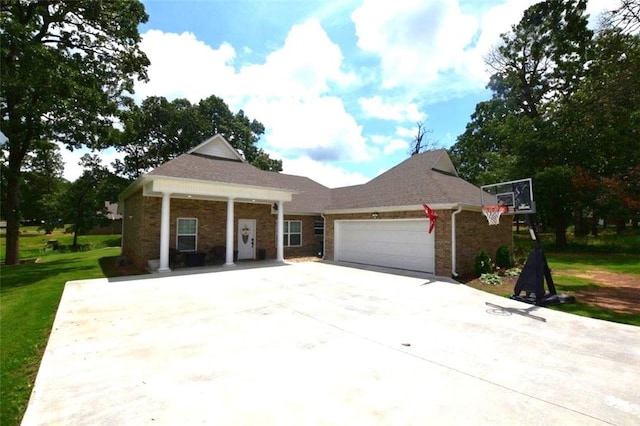 view of front of home featuring a garage, concrete driveway, brick siding, and a front lawn