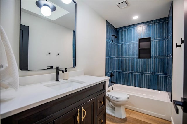 full bathroom featuring toilet, wood finished floors, visible vents, bathing tub / shower combination, and vanity