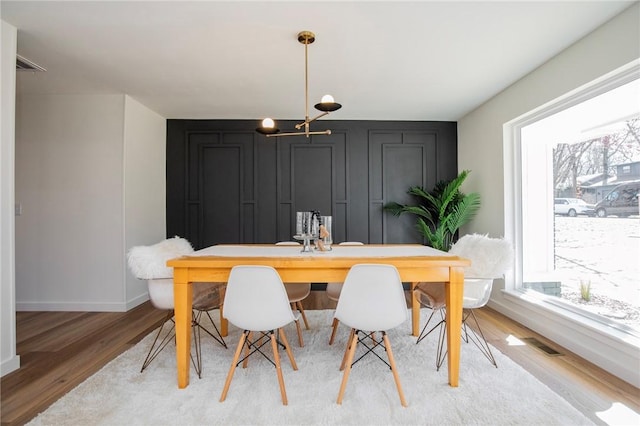 dining area with light wood-type flooring and baseboards