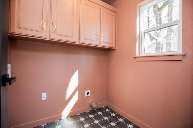 laundry room with dark floors, cabinet space, electric dryer hookup, and baseboards