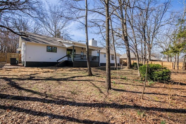 exterior space featuring a chimney, fence, and central AC unit