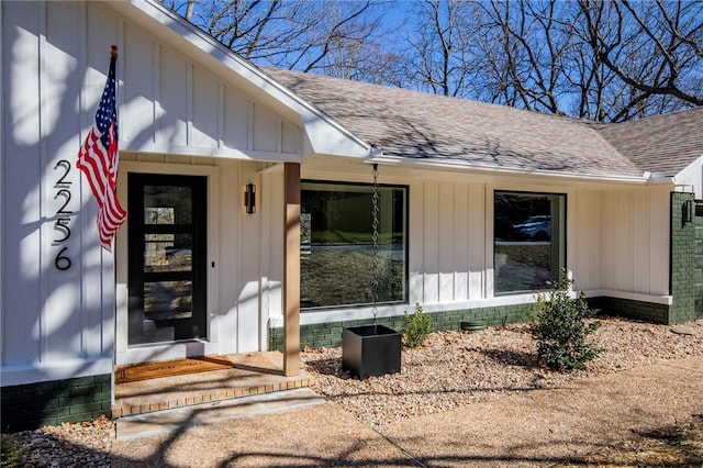 property entrance with crawl space, a shingled roof, and board and batten siding